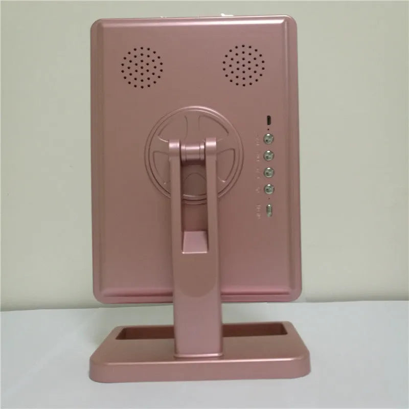 Pink and white touch screen LED makeup mirror with Bluetooth speaker and magnifying glass on a table.