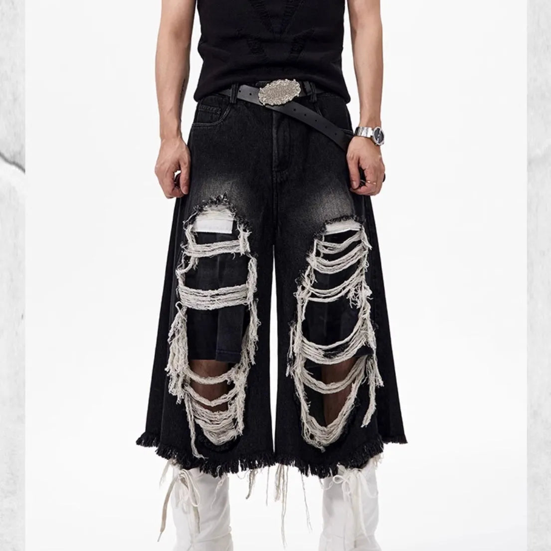 Black wide-leg cropped jeans with a ripped patch detail on the leg, showing a mid-high waist and loose fit.