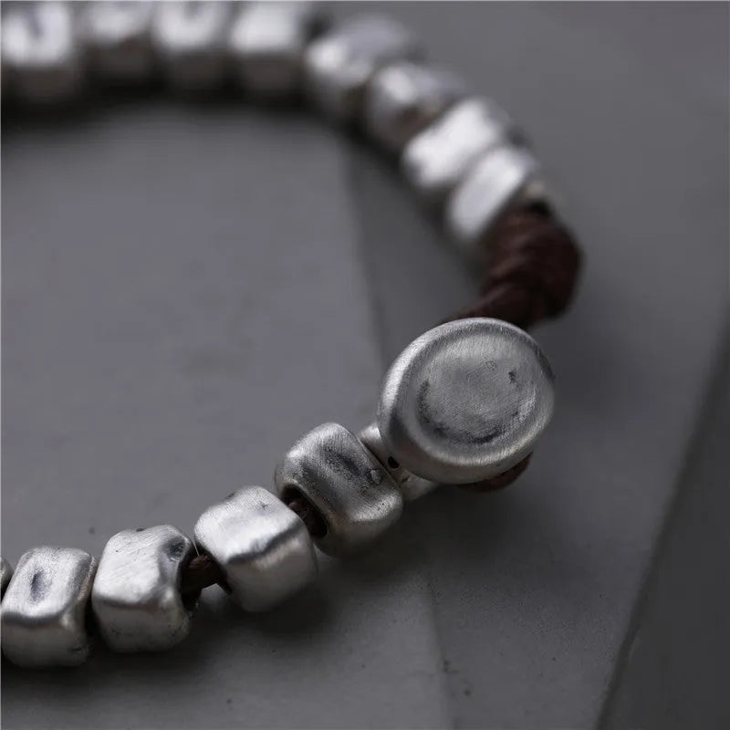 Women's handmade bracelet with irregular silver squares and wooden accents on elastic band