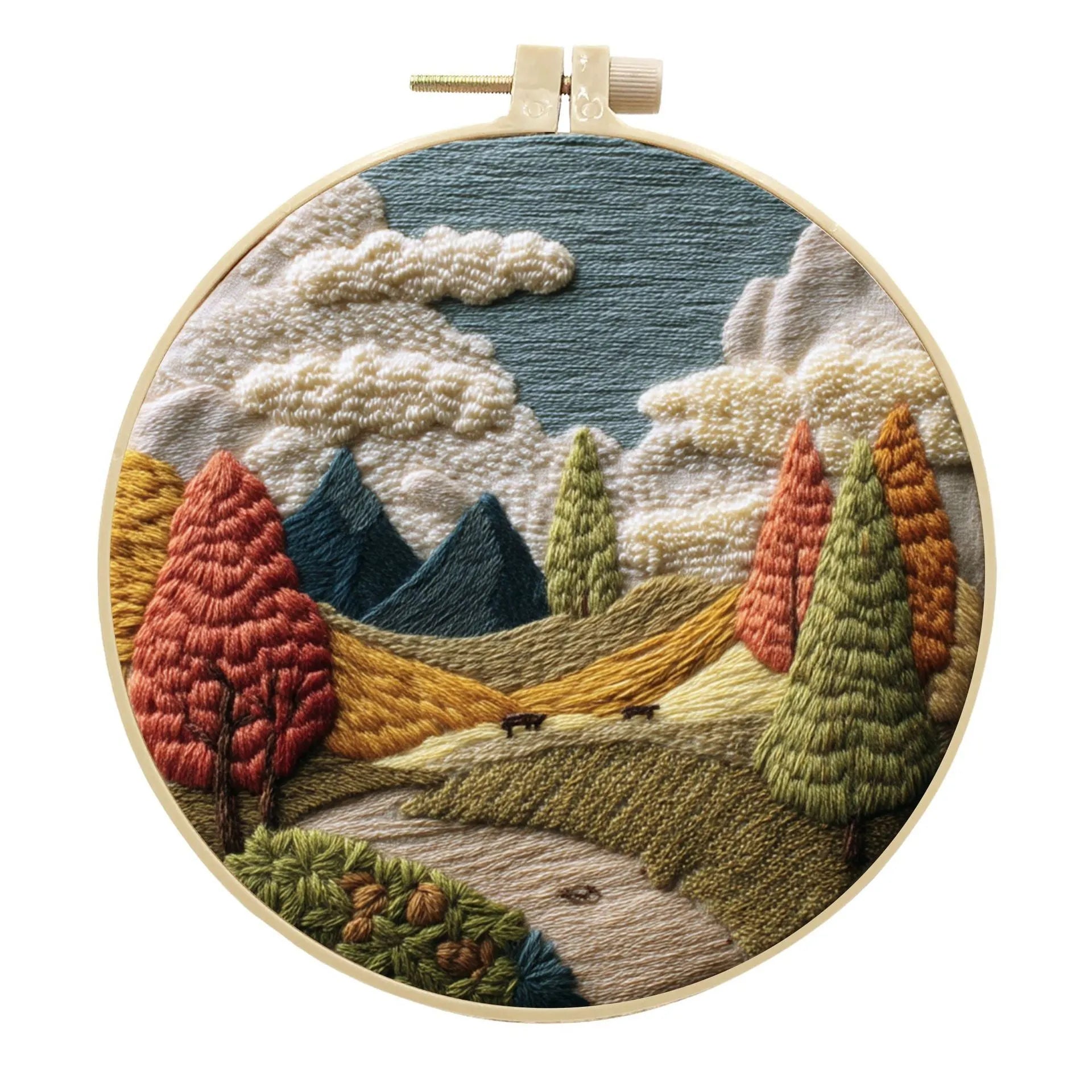 Complete DIY embroidery kit showing pre-printed landscape fabric, coloured threads, needles, and an embroidery frame.