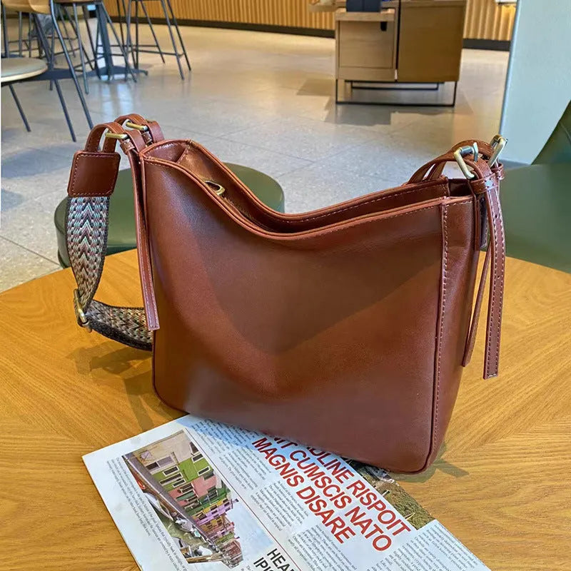 Women's black genuine leather messenger bag with multiple compartments and shoulder strap