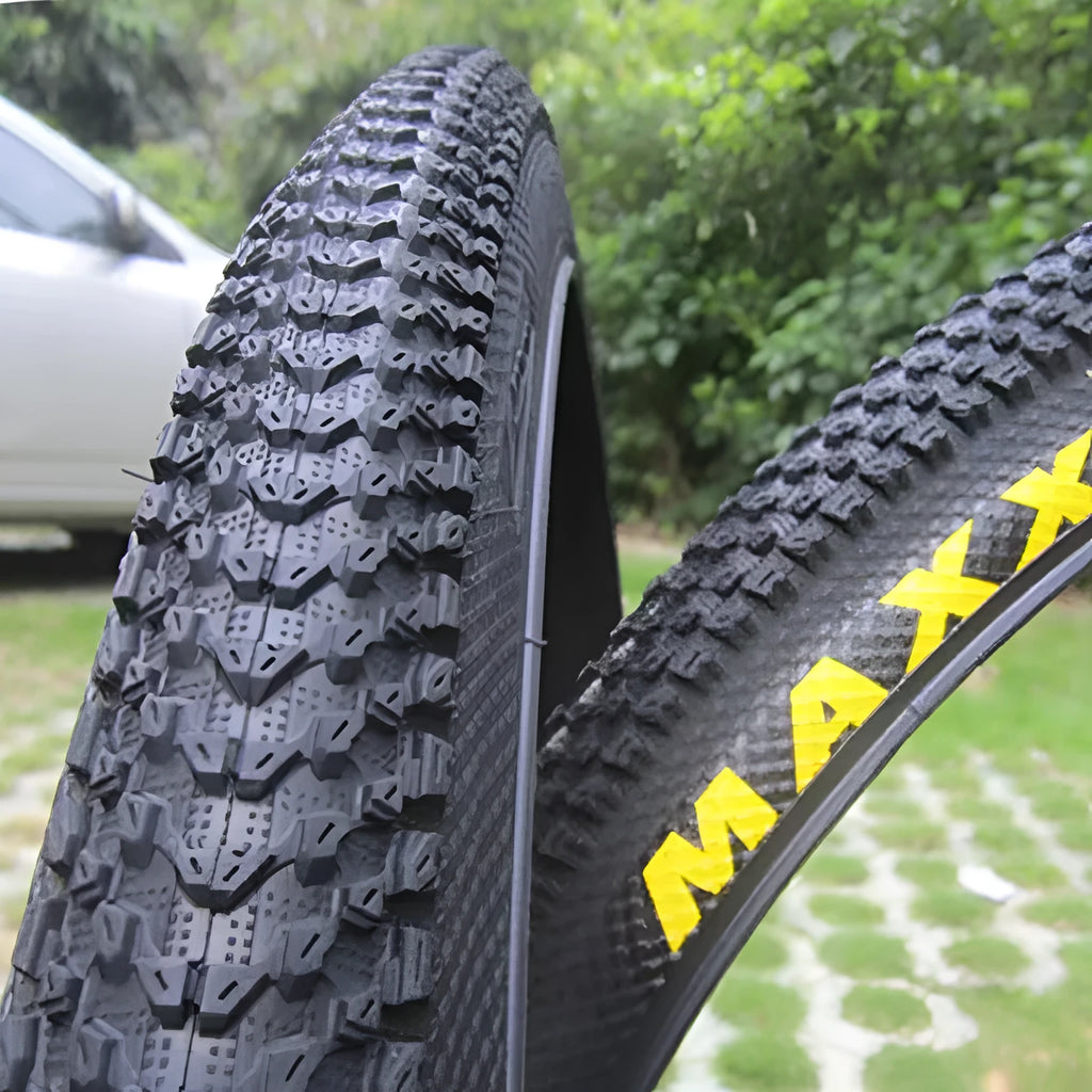 Ultralight puncture-proof mountain bike tyre in multiple sizes on a grey background.