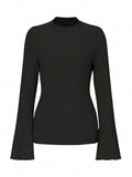 Man wearing a black slim-fit long sleeve top with lantern sleeves and a subtle stripe pattern.