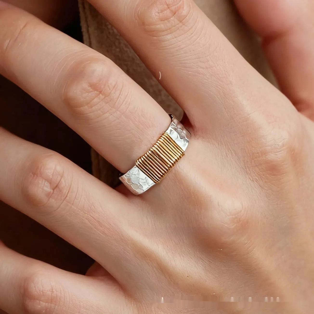 Silver golden geometric coil copper ring for men and women on a grey background.