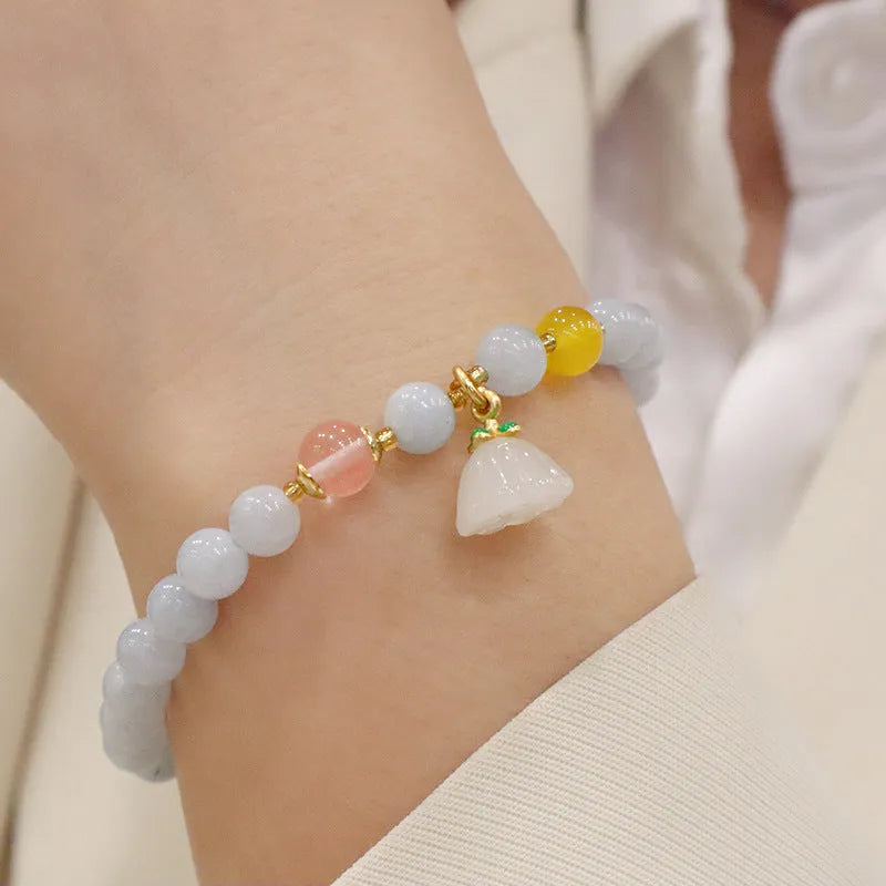 Gold plated women's bracelet with aquamarine chalcedony crystal pendant and floral design.