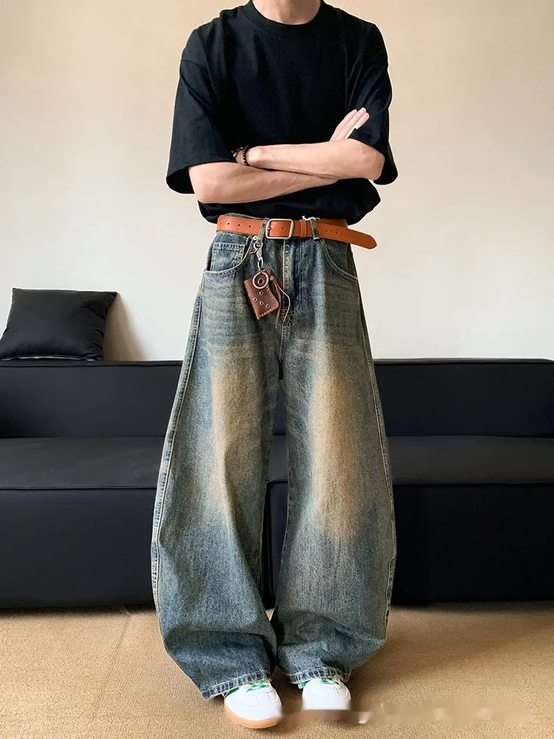 Men's retro blue distressed denim jeans with a slimming wide-leg fit and machete wash detail.