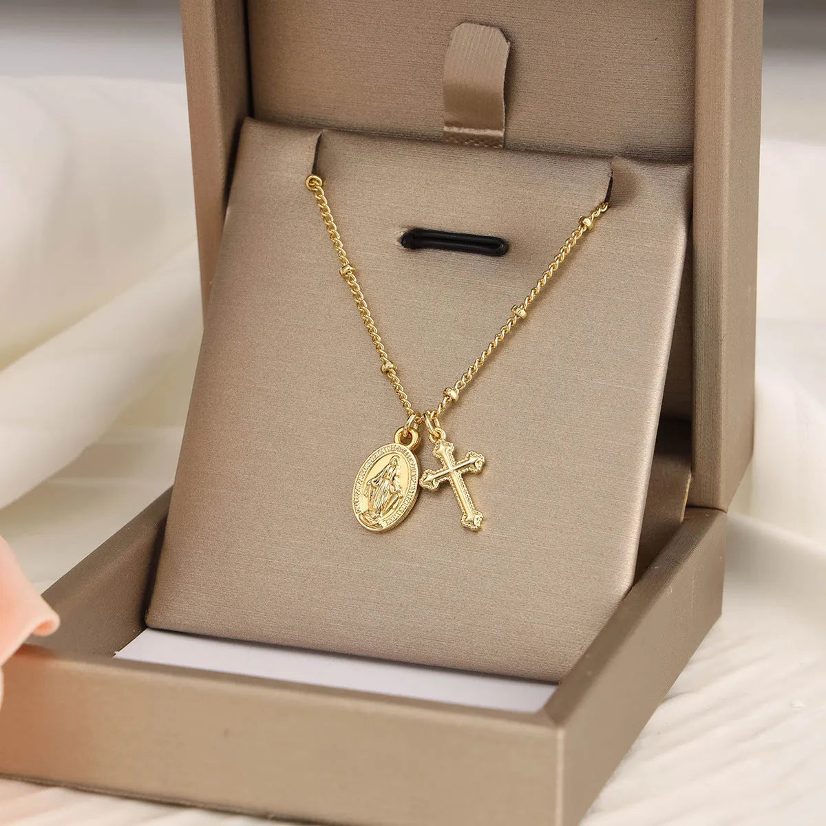 Gold geometric pendant necklace featuring the Virgin Mary on a chain.