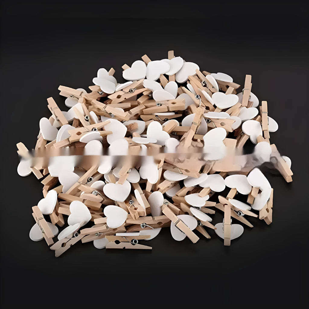 Set of five small red, pink, and white solid wood heart-shaped clips on a surface.