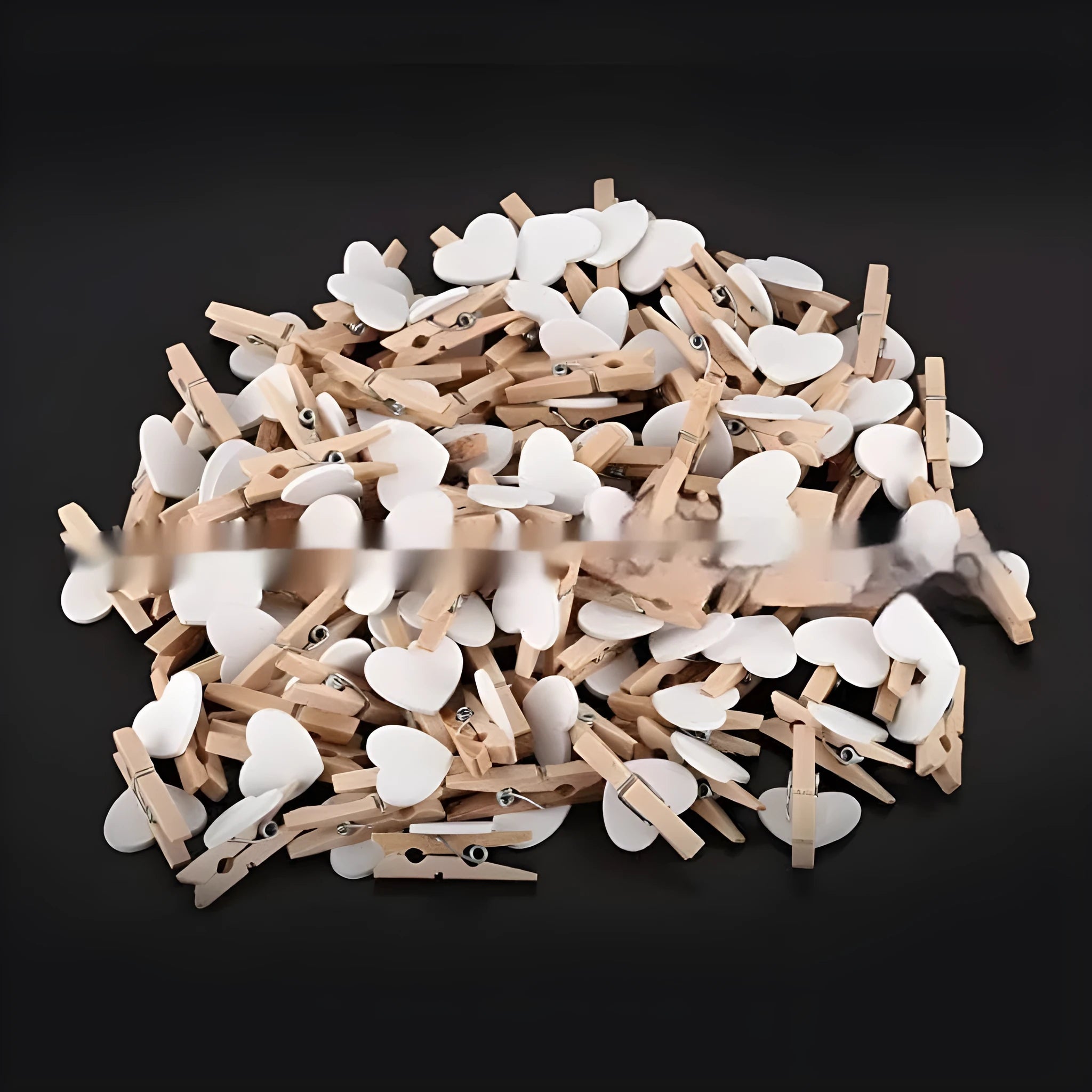 Set of five small red, pink, and white solid wood heart-shaped clips on a surface.