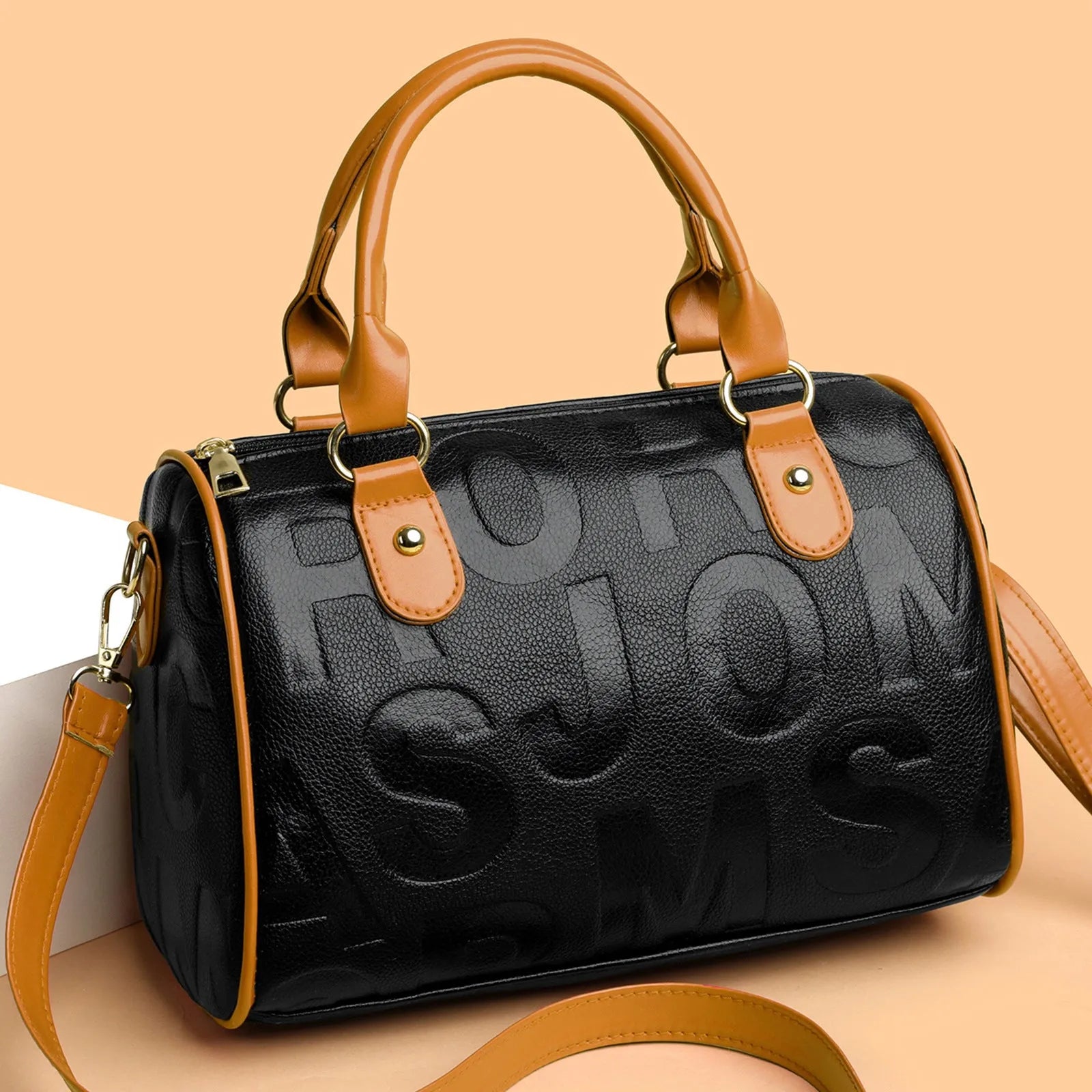 Cylindrical brown PU leather crossbody bag with three shoulder straps displayed