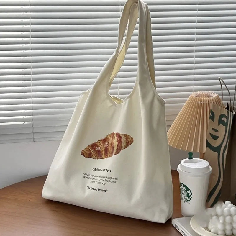 Beige canvas shoulder bag with bread design showing front width and shoulder strap
