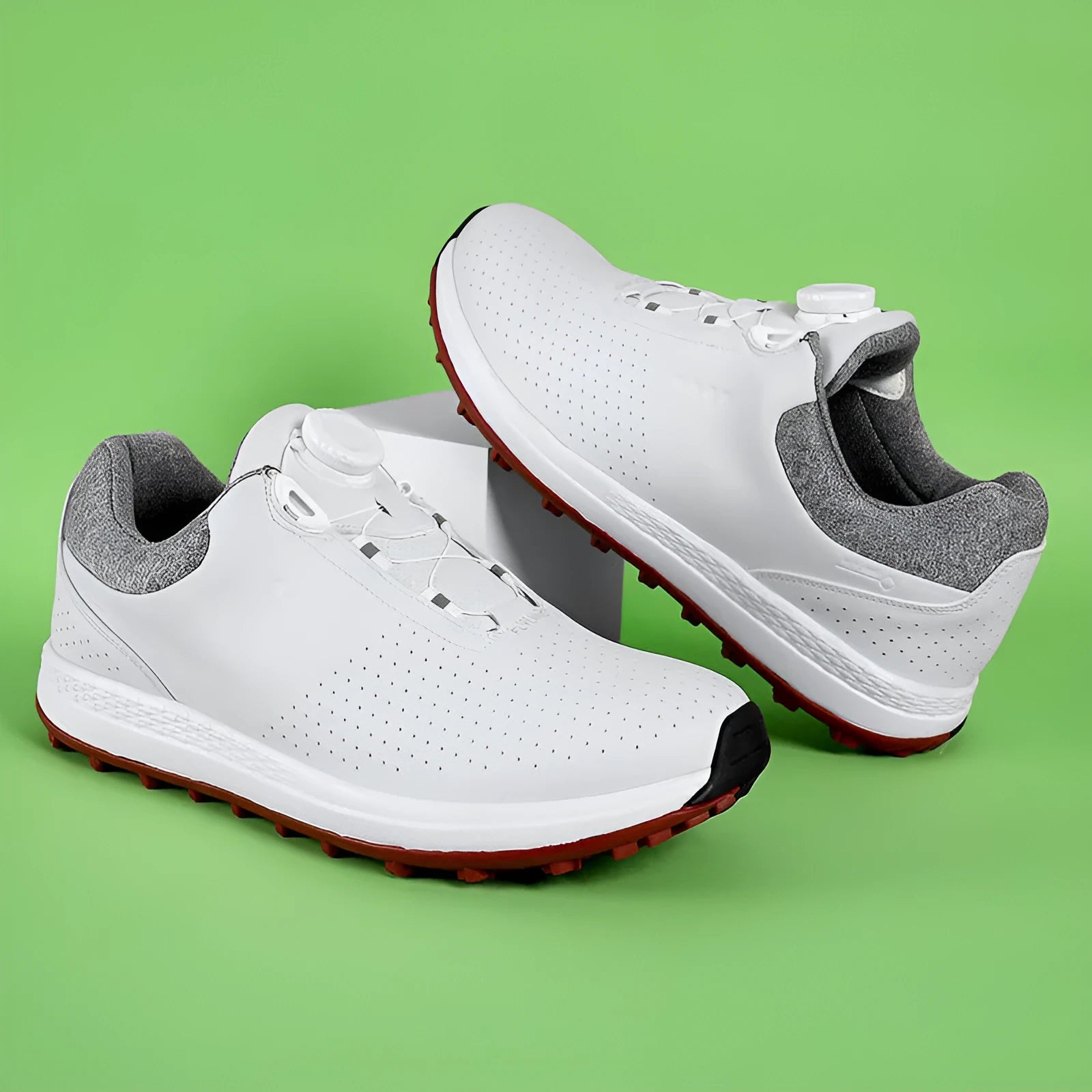 Men's low-top white golf sneakers with breathable hollow-out sole on grass.