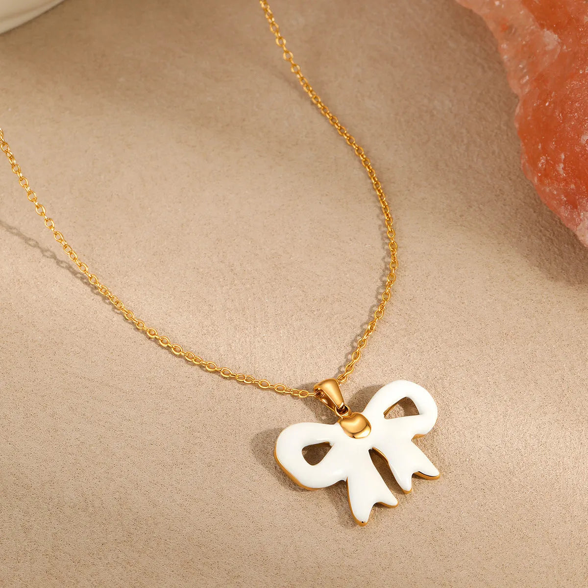 Bowknot stainless steel pendant necklace on white background, adjustable 41-50cm chain, 18K gold-tone finish