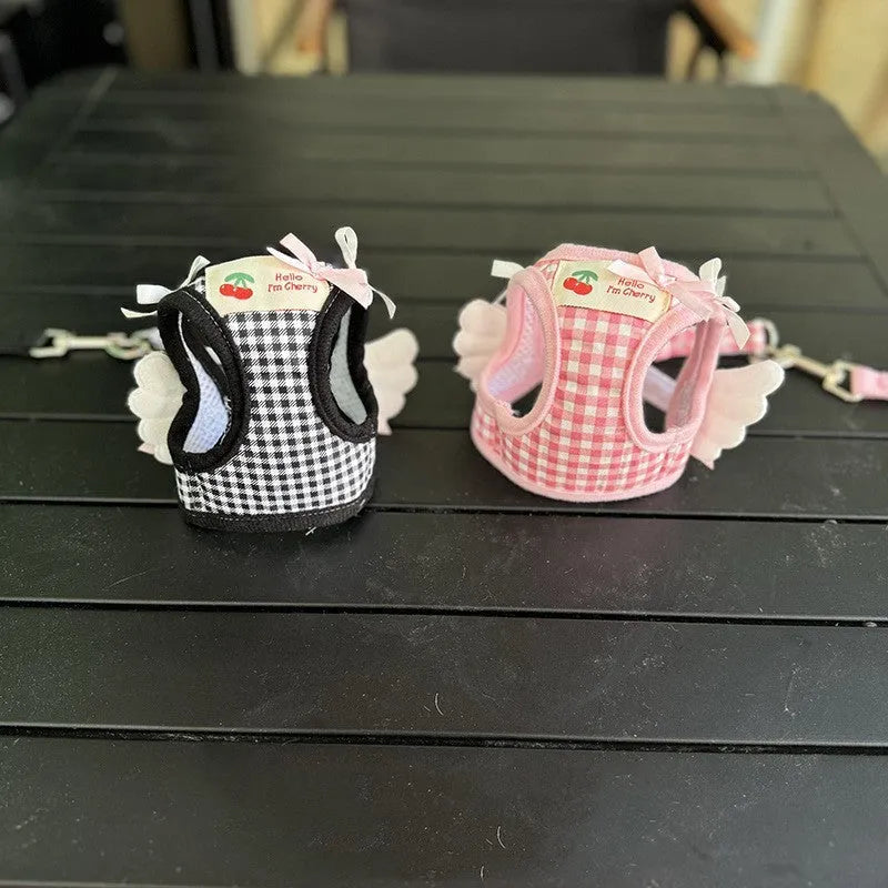 A pink cotton chest and back harness with a hand holding rope for a small dog.
