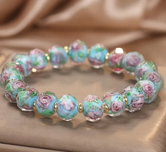 Colour changing artificial crystal bracelet with rose heart design in lake blue finish against a light background