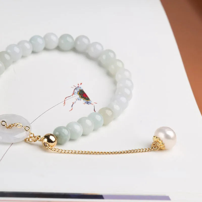 Jade and pearl bracelet with geometric pendant and peace buckle charm on wrist