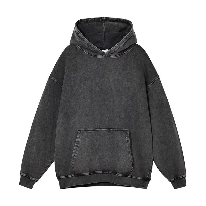 Man wearing a loose, brown, batik-washed cotton pullover hoodie with drop-shoulder sleeves.