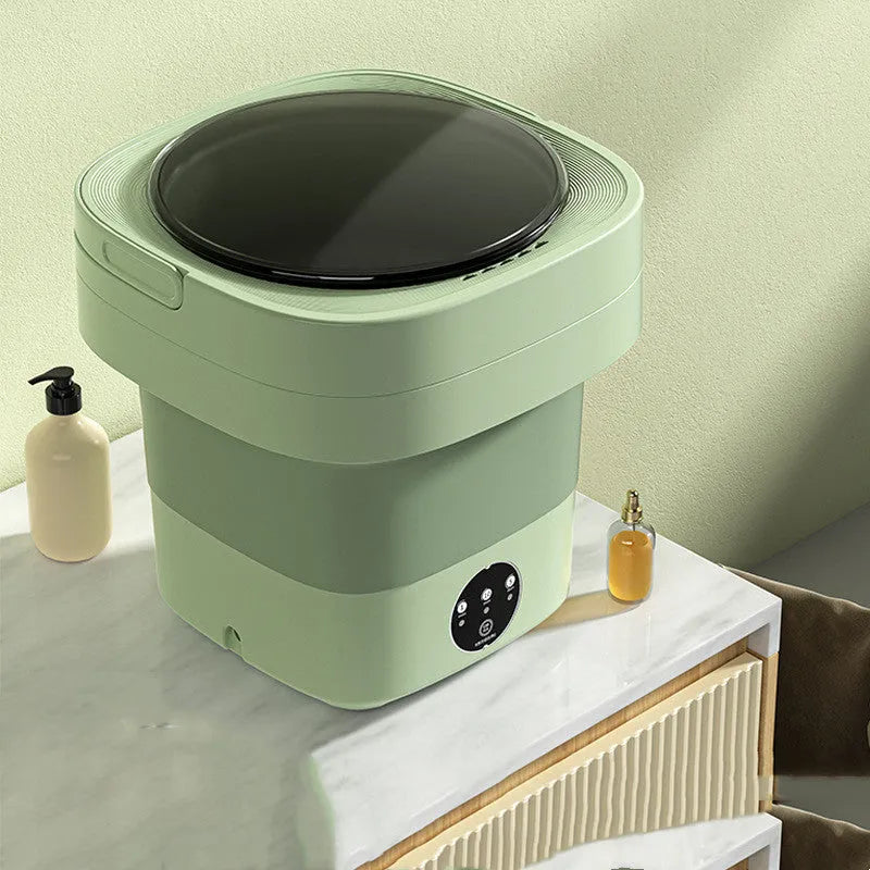 Green foldable mini portable washing machine with drain pipe and basket on a white background.