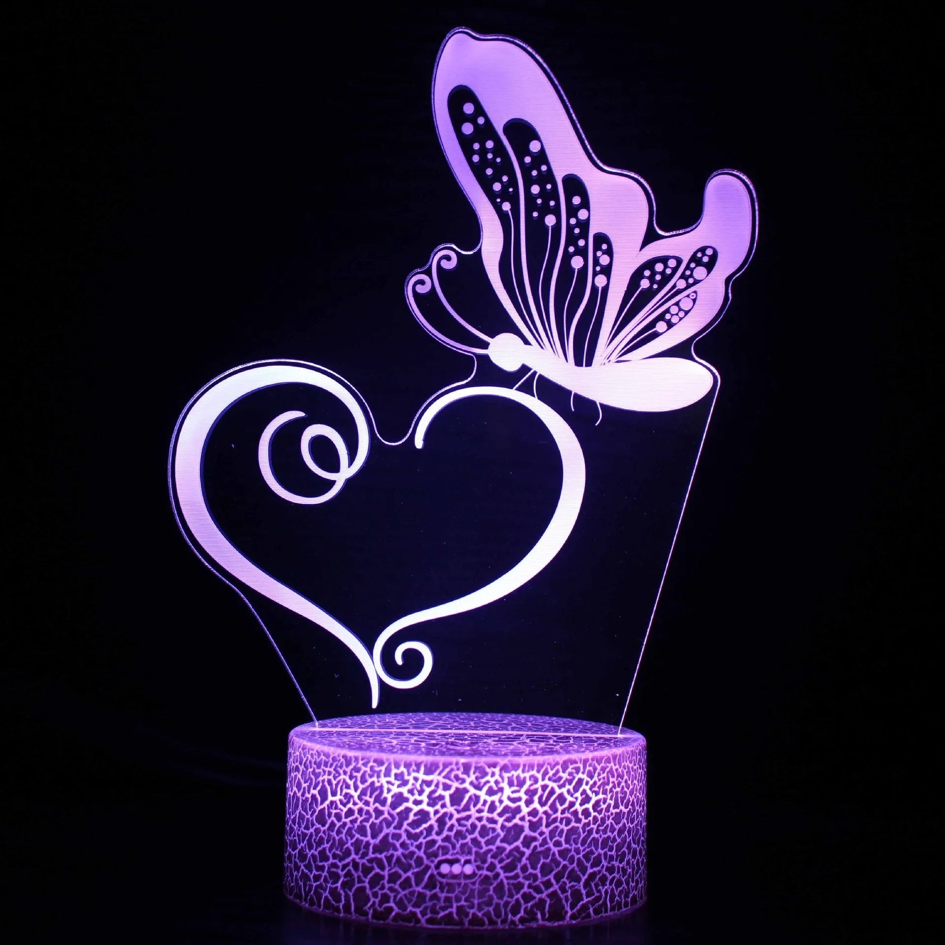 Acrylic USB touch night light with colourful crack base design on a bedside table.