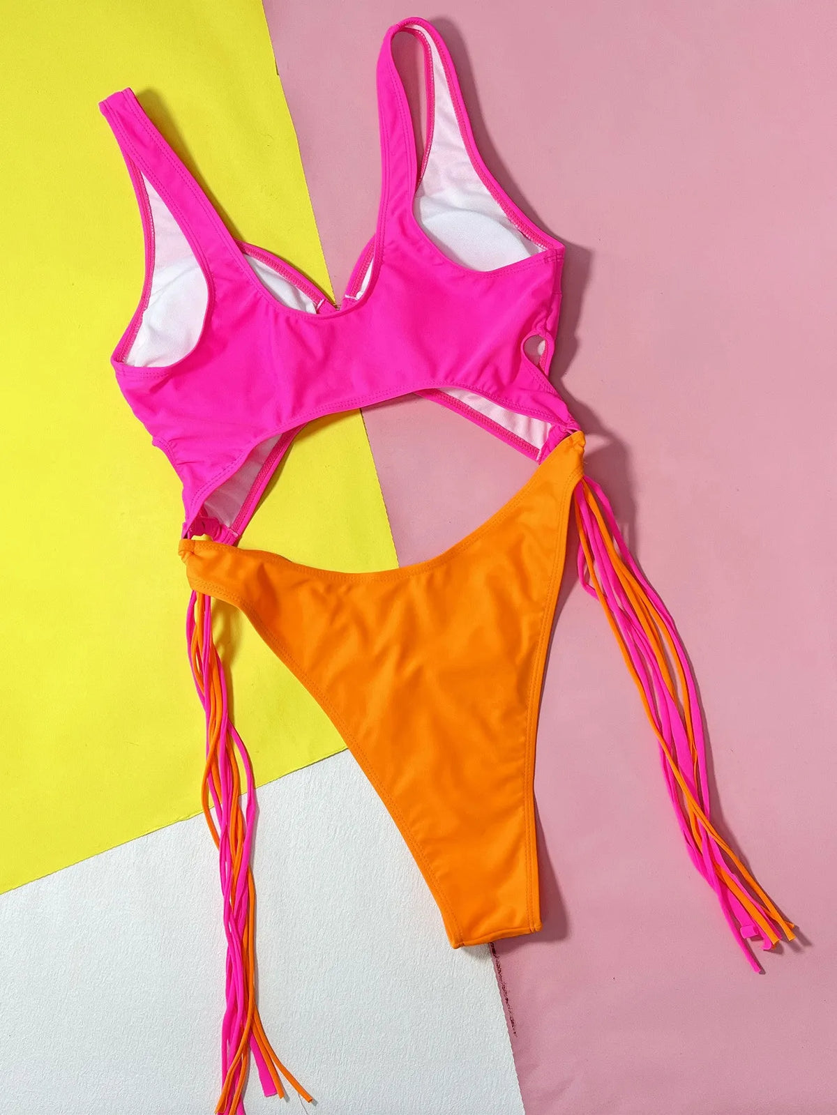Women's rose red hollow-out steel ring tassel one-piece swimsuit on display