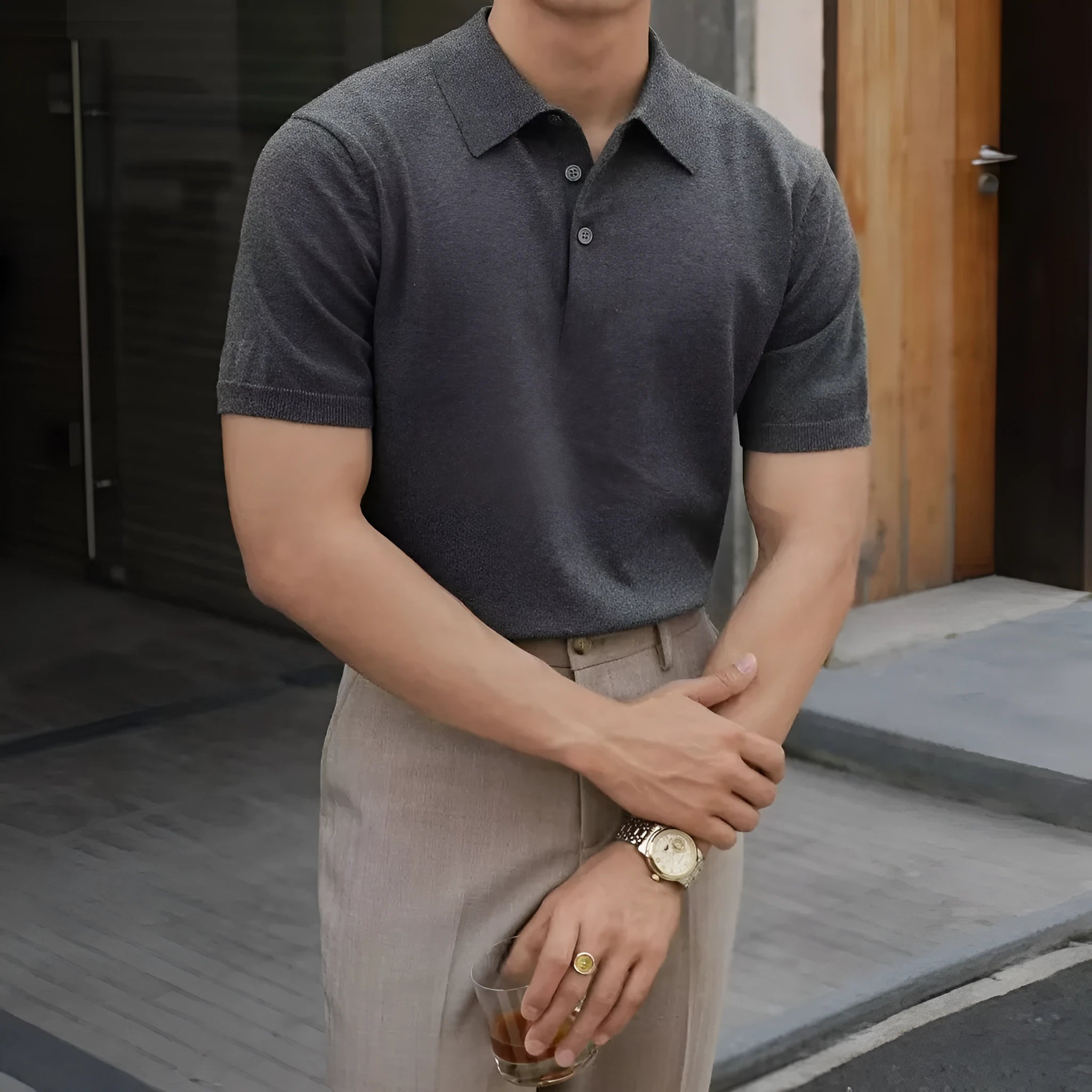 Men's black polo shirt with knitted collar and short sleeves laid flat.