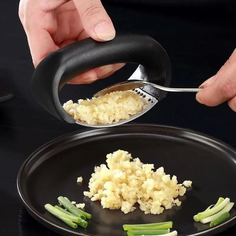 Stainless steel garlic press with curved ergonomic design and non-slip handle in assorted colours.