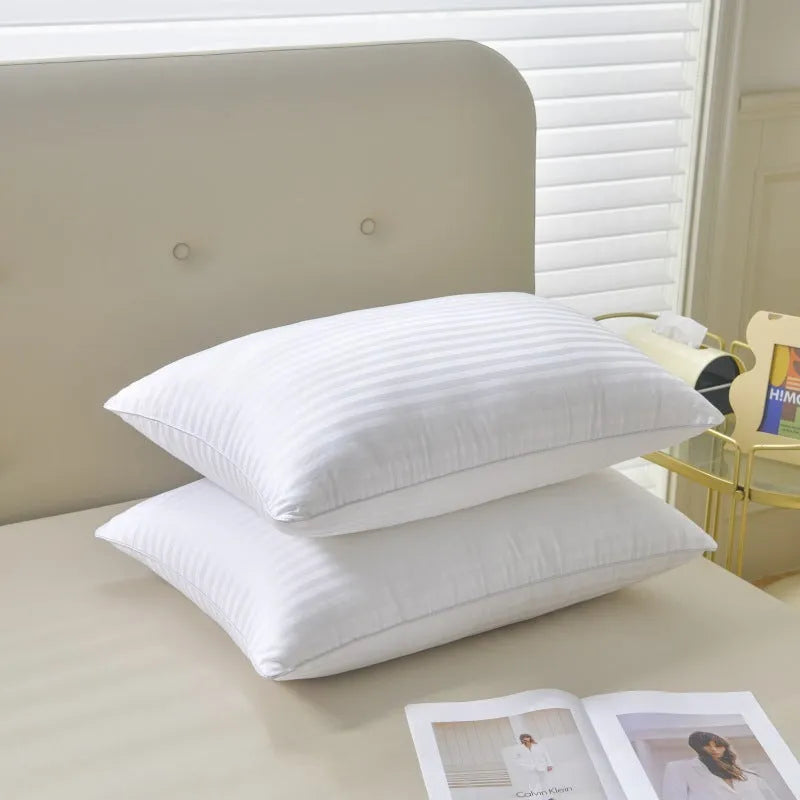 White cotton satin stripe feather and cotton pillow shown in a simple style on a bed.