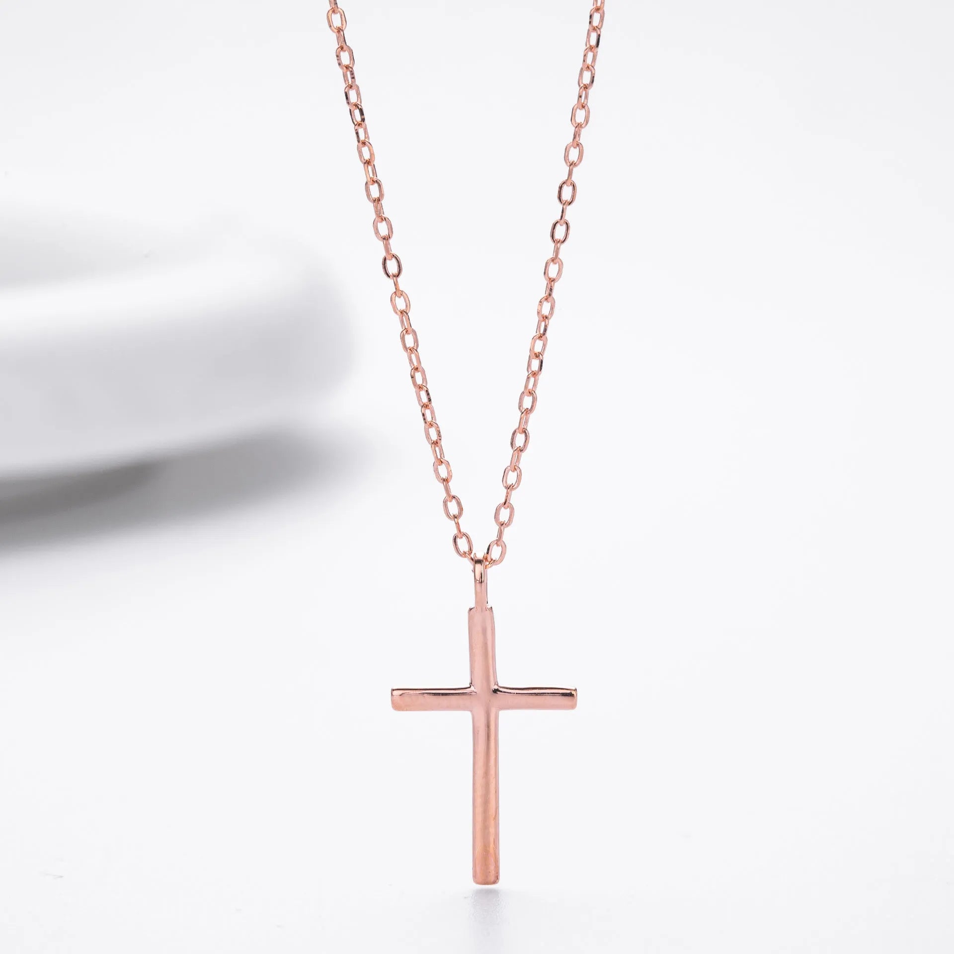 Simple glossy cross pendant on an O-shaped sterling silver chain necklace.