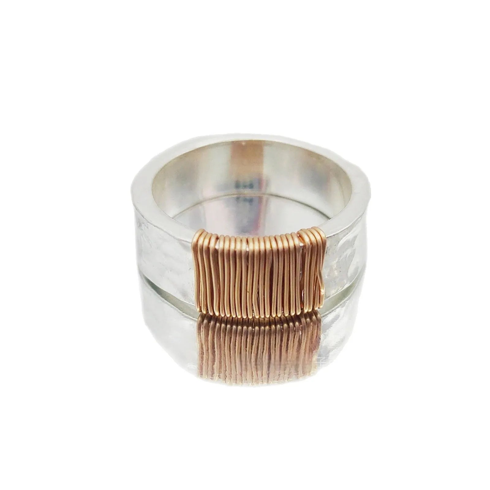 Silver golden geometric coil copper ring for men and women on a grey background.