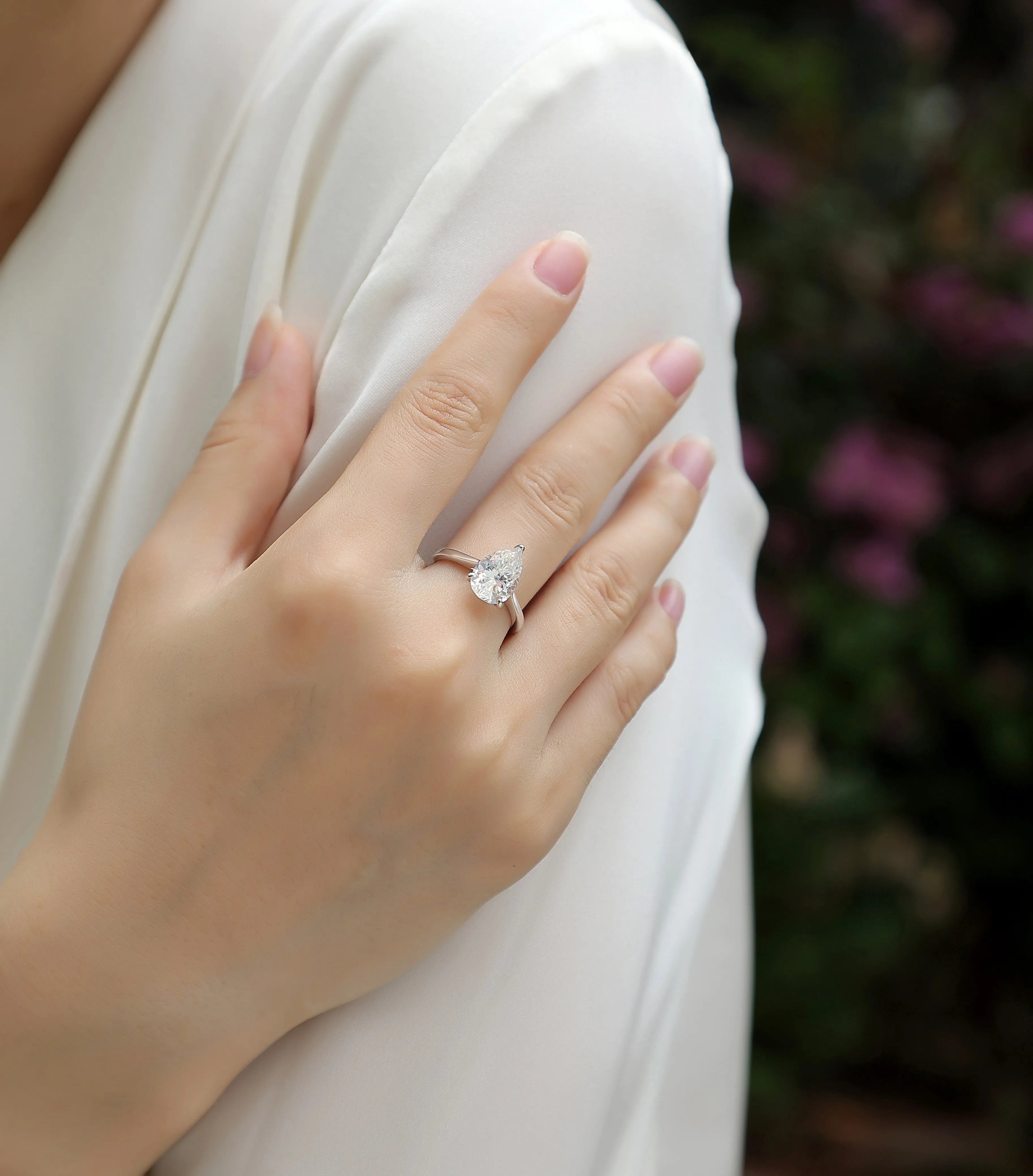 Heart-shaped pear-cut moissanite wedding ring set in S925 silver with platinum plating on white background