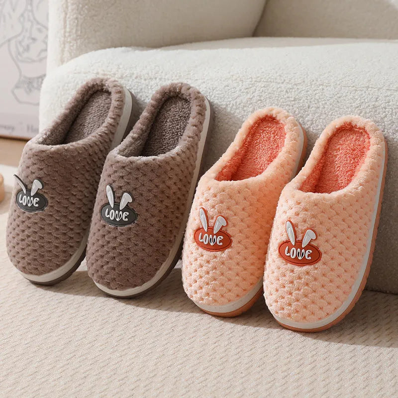 Rabbit plaid design artificial fur house slippers with a non-slip rubber sole.