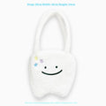 White plush tote bag with a cute teeth graphic, showing the crossbody strap and zipper opening.