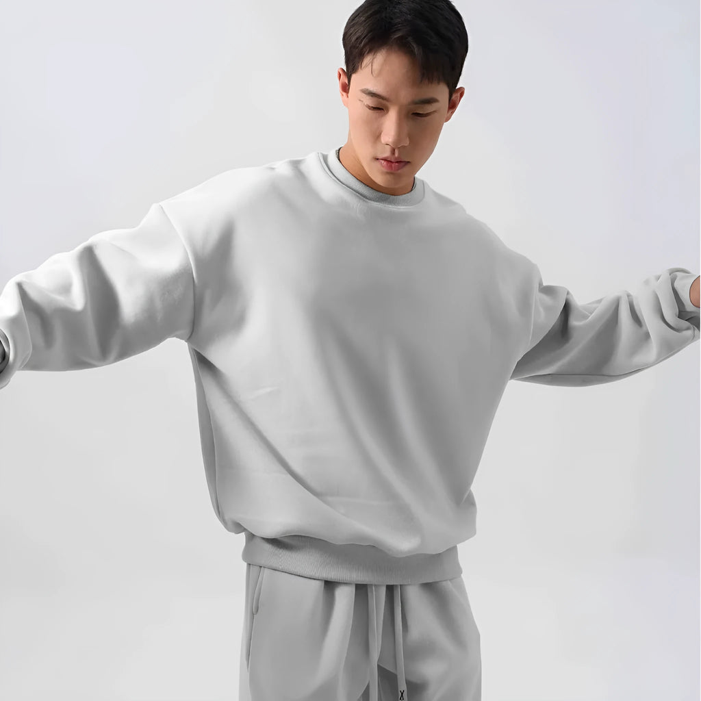 Men's black polar fleece sports suit with crew neck jacket and loose fit trousers laid flat.