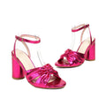 Gold women's high heel peep toe sandals with an ankle buckle on a white background.