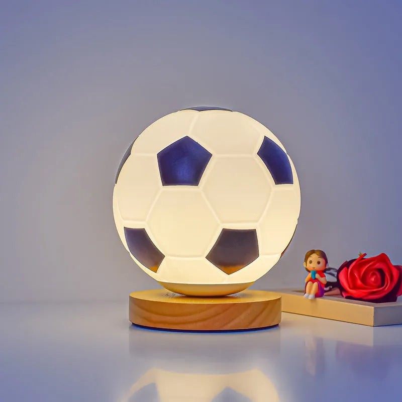 Football LED small night lamp with glass shade and remote control on a bedside table