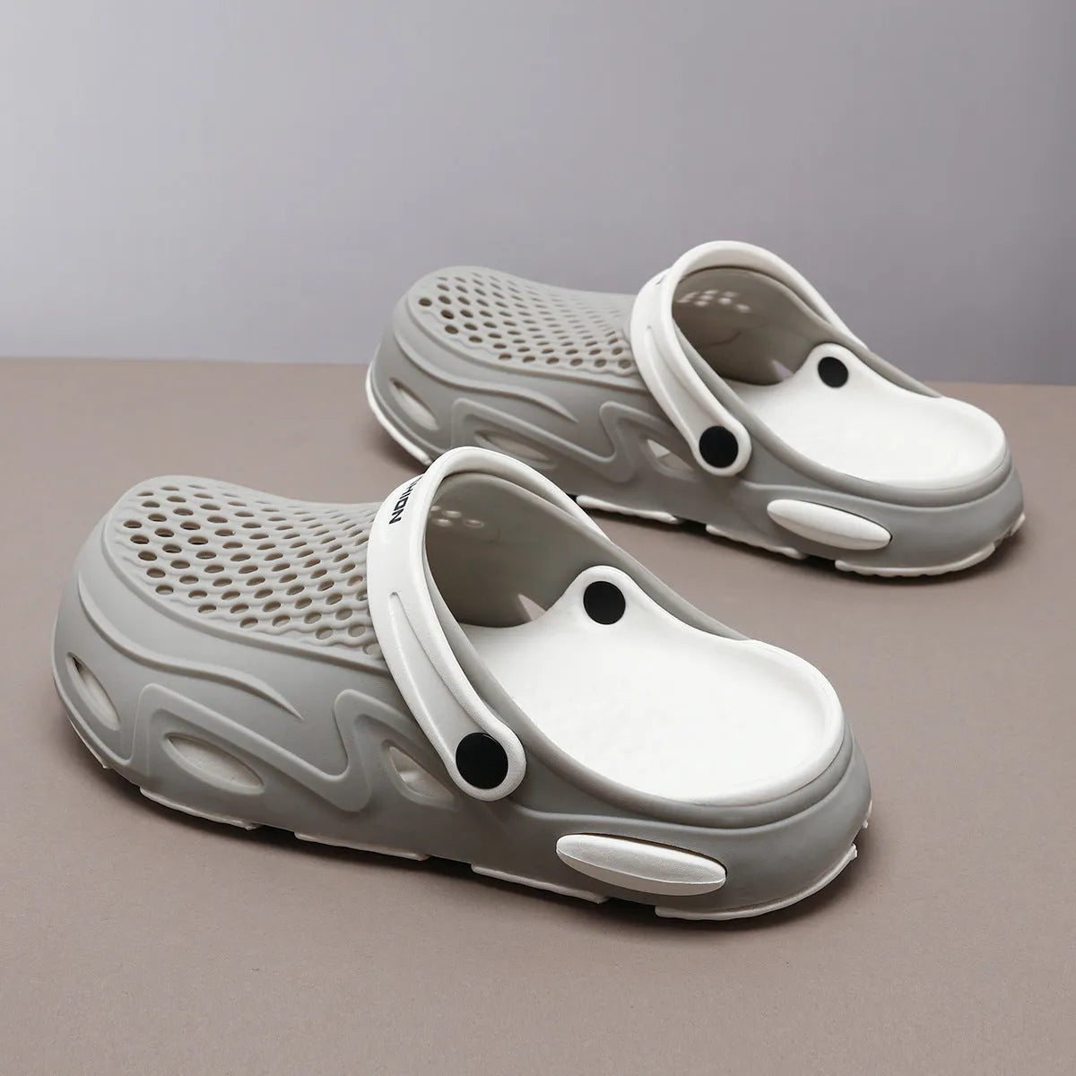 Men's grey closed toe EVA beach slippers with a non-slip sole and flat heel on a poolside.