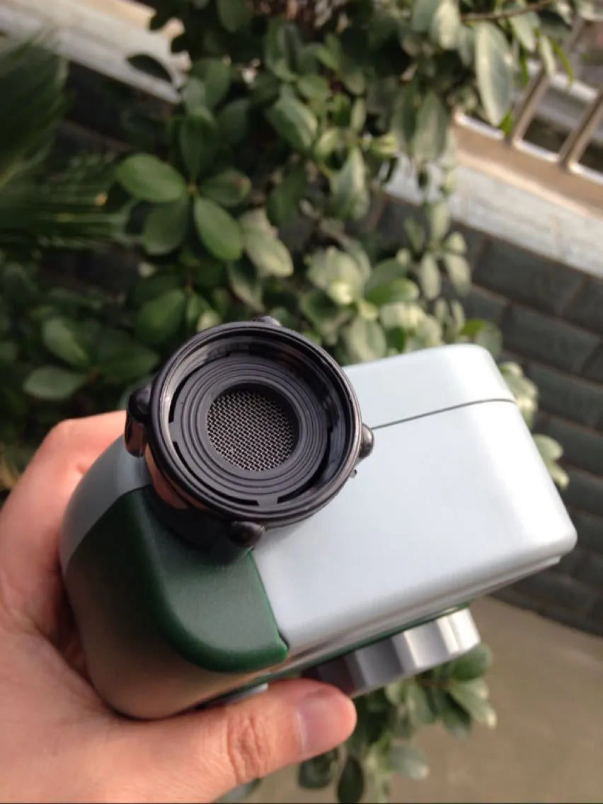 Green digital programmable water timer with display and dial attached to a garden hose faucet.