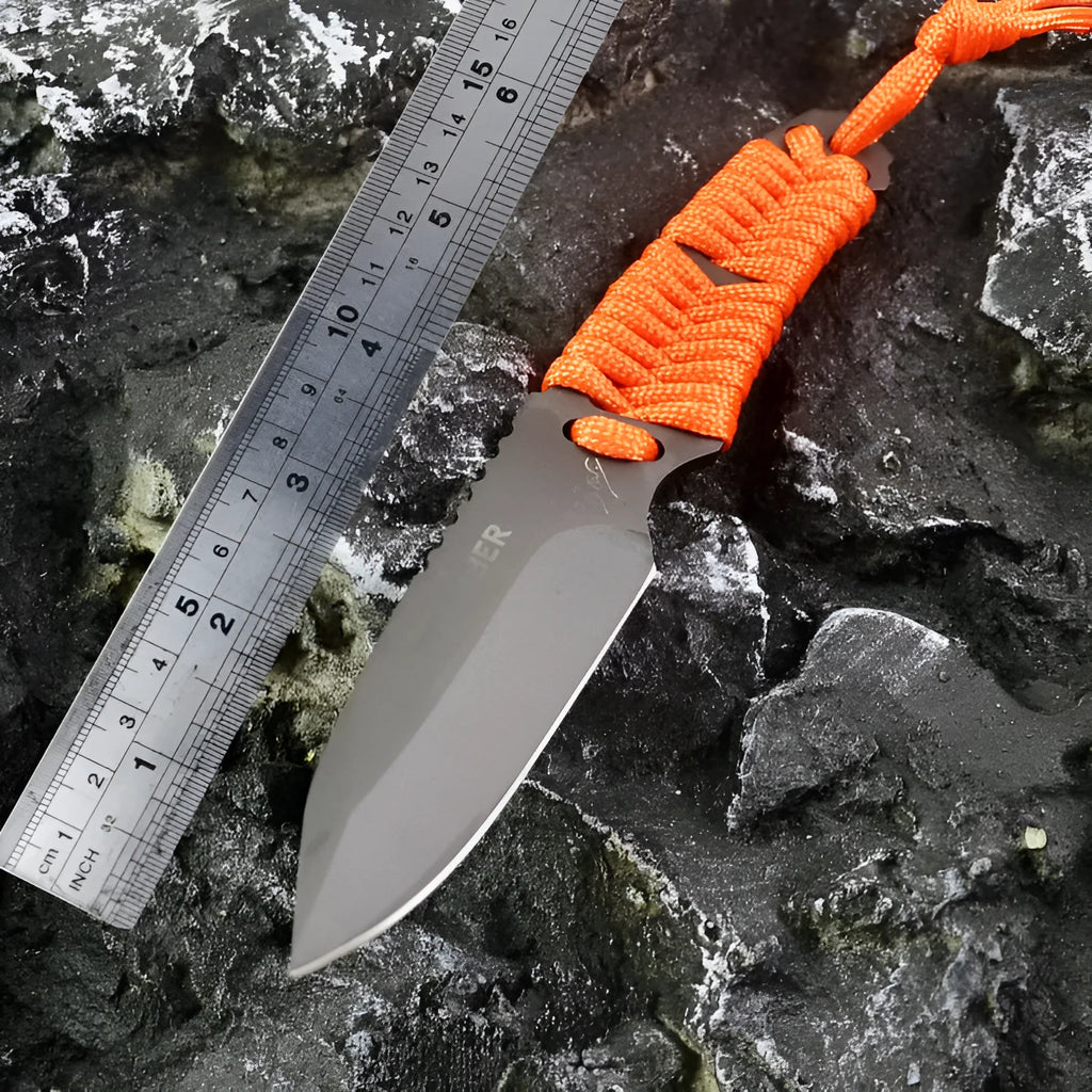 Straight survival knife with rope handle and black ABS sheath on a paper box.