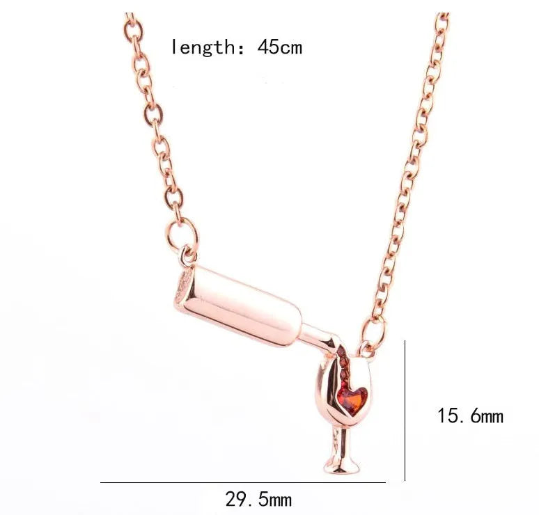 Gold alloy wine bottle and glass pendant necklace on a light background