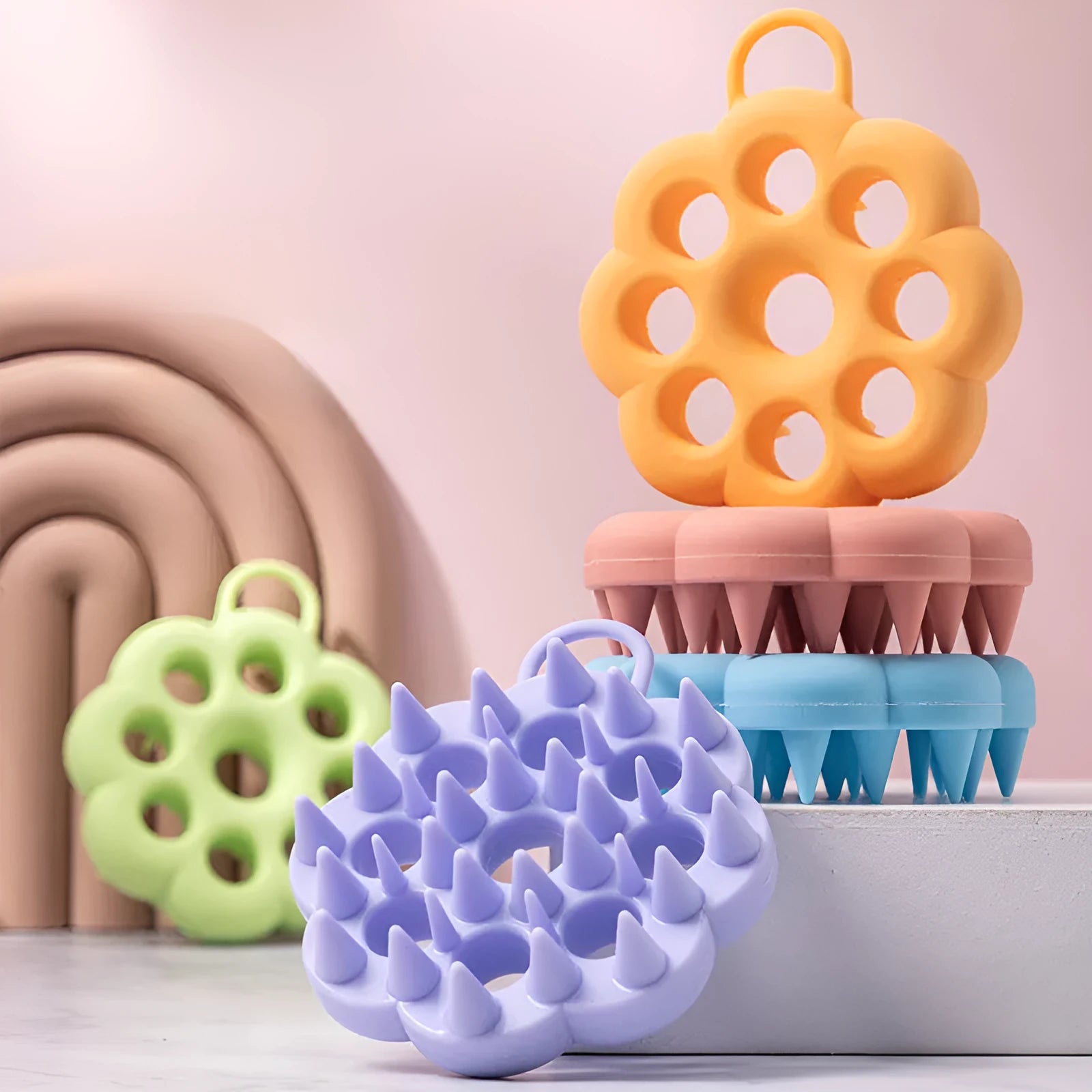 Silicone pet grooming brush with ergonomic handle shown in multiple colours: blue, green, orange, pink, purple.