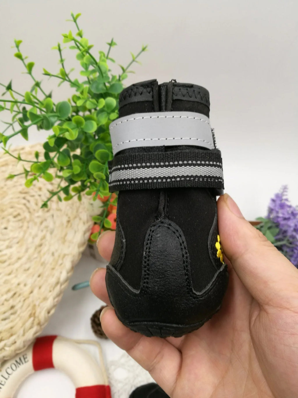 Black dog shoes with waterproof PVC sole and adjustable fuzzy belt on a white background