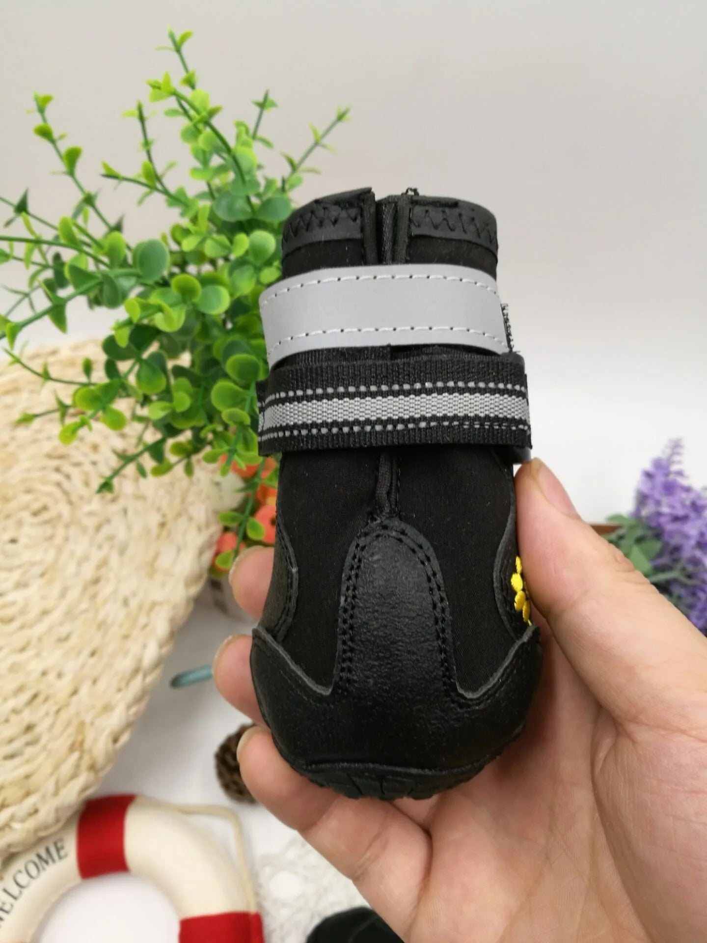 Black dog shoes with waterproof PVC sole and adjustable fuzzy belt on a white background