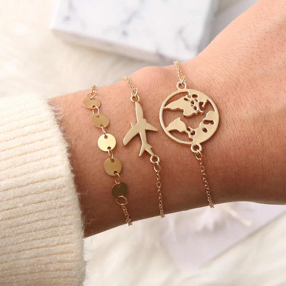 Set of three bohemian-style women's bracelets with heart-shaped aircraft map charms in alloy.