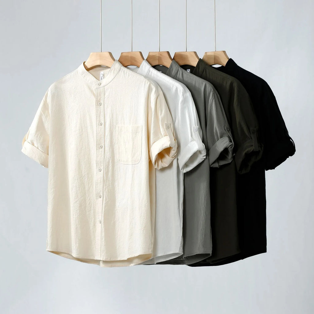 A man's loose-fitting, short-sleeved linen shirt in a solid colour with a stand collar.