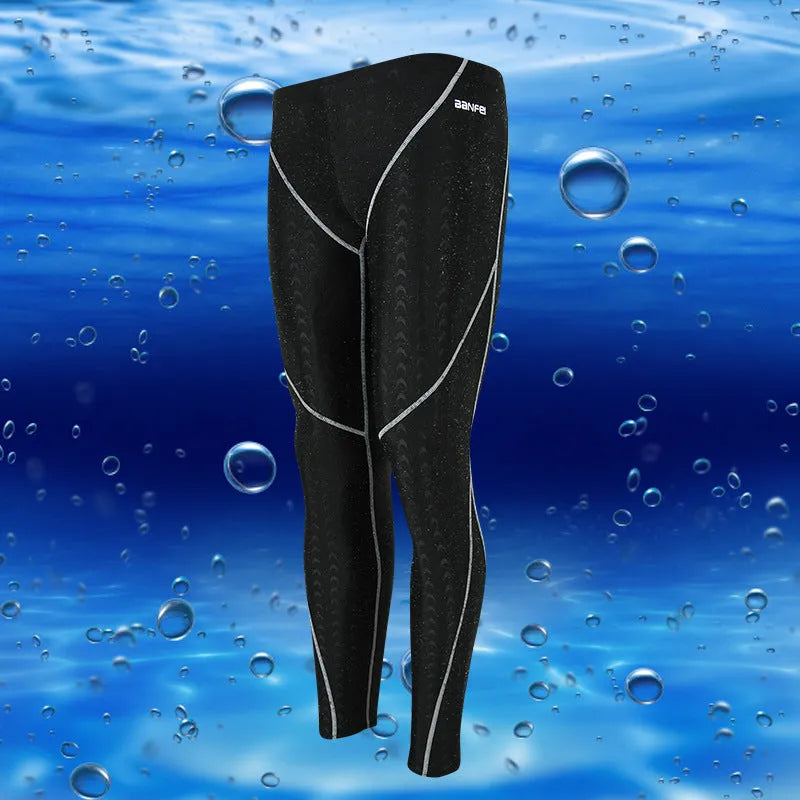 Men's black and grey cropped nylon swimming trunks with mesh lining laid flat.