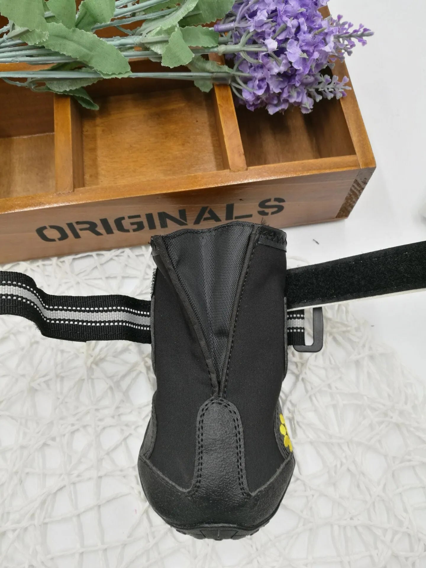 Black dog shoes with waterproof PVC sole and adjustable fuzzy belt on a white background