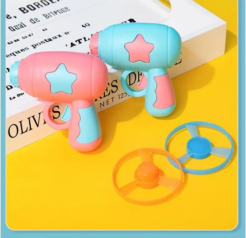 Blue interactive cat toy gun with a plastic frisbee on the launch head, shown next to a second pink frisbee.