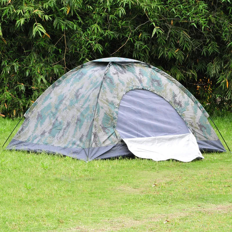 Green camouflage two-person camping tent with fibre glass poles and steel pegs pitched outdoors.