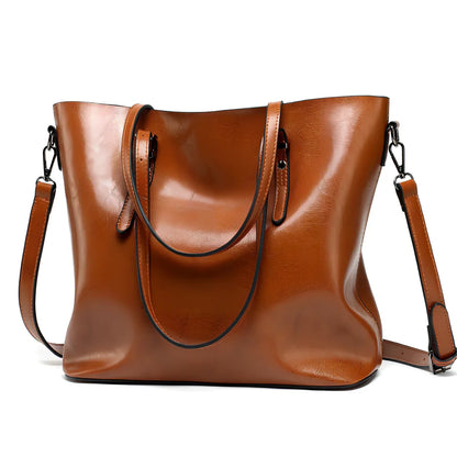 Black oil leather tote bag with square shape, zipper top, soft handle, and internal pockets for winter use