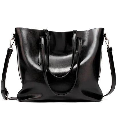 Black oil leather tote bag with square shape, zipper top, soft handle, and internal pockets for winter use